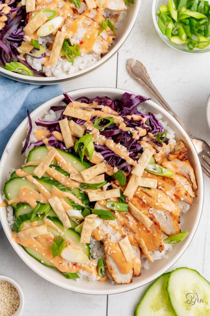 The complete bang bang chicken bowl is served with all the toppings in a white bowl.