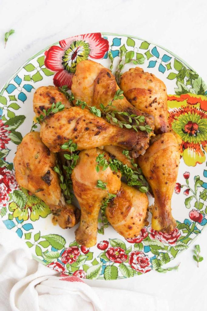 Baked Chicken Legs recipe on a colorful plate served with fresh thyme sprigs