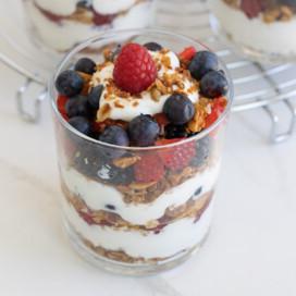 A single yogurt breakfast parfait with layers of fruit, granola, and yogurt.
